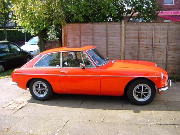 My 1970 MGB GT in (almost) Flame Red. Looking pretty good in the sunlight, but in fact there is a rust hole in the door and that front wing is all but shot! Never mind, it gets well used.For more pics see my website, which is linked from the links page.